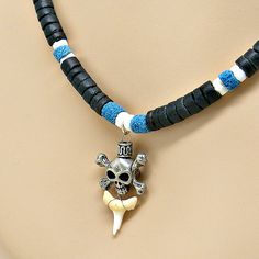 "Worn by SUP, Surfers, and Beach lovers everywhere Pewter Skull X Bones with Shark Tooth Pendant is 3D 3/4\" wide x 1\" high (19mm x 25mm) Necklace made with Black 5-7mm Graduated Coconut Shell Beads Puka Shell Beads and Blue Sand Cast Beads The closure is a barrel screw style Choice of lengths 18 inch (46cm21 inch (53cm24 inch (62cm) *21 and *24 inch lengths are obtained by adding a 5mm diameter coconut shell bead extender piece as pictured above Style 7068_8 Located in Sunny Tropical Florida U Shark Tooth Pendant, Seashell Beach, Tooth Pendant, Shark Tooth Necklace, Tooth Necklace, Puka Shell, Shell Beach, Shark Tooth, Seashell Necklace