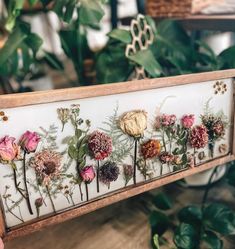 a wooden frame with dried flowers on it