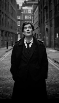 a man in a suit and tie standing on a street