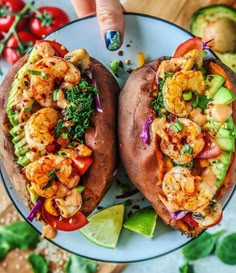 two loaded sweet potatoes with shrimp, avocado and cilantro on them