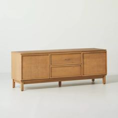 the sideboard is made from wood and has two drawers on one end, and three doors on the other