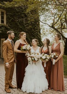 a group of people standing next to each other on a brick floored area with trees in the background