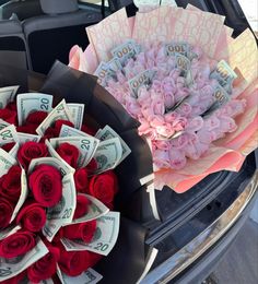 two bouquets of roses are sitting on the back of a car with money in it