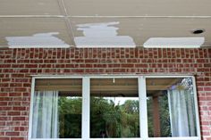 a brick wall that has been painted with white paint and is being replaced by a window