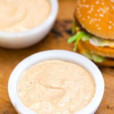 a close up of a plate of food with a sandwich and some dipping sauces