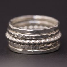 A handmade sterling silver stacking rings set, perfect for everyday use.  This is a set of 5 dainty silver stackable rings, as shown in the photos. The set includes: 2 rings made from 1.5mm wide sterling silver, hammered in a faceted pattern 2 rings made from 1.5mm wide sterling silver, hammered in a ridged pattern 1 ring made from 2mm wide sterling silver pearl ball wire The stackable rings shown in the photos have a shiny polish finish but they can also be made with a satin finish. Please leave me a note during the checkout process if you would prefer a satin/matte finish. If you would like to purchase a custom set of 1-4 stackable rings, please use this listing: https://www.etsy.com/listing/249341418/sterling-silver-rings-stacking-rings  SIZING: We have given US size options but are ver Silver Sterling Rings, Silver Rings Women, Stacking Rings Silver, Ladies Silver Rings, Rings Dainty, Rings Stacking, Stackable Rings Silver, Faceted Ring, Dainty Rings