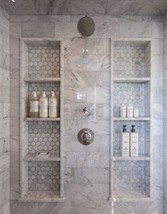 a bathroom with marble walls and shelves in the shower