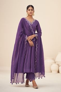 Purple scallop trim neckline anarkali, highlighted with mirror work neckline and cuffs. Paired with a scallop trim, mirror work pant and dupatta.
Components:3
Pattern:Embroidery
Type of Work:Mirror
Neckline:V Neck
Sleeve Type:Full Sleeves
Fabric:Kurta and Pant: Cotton Silk, Dupatta: Organza, Inner Lining: Crepe
Color:Purple
Other Details:
Scallop trim, mirror work dupatta
Occasion:Sangeet,Mehendi and Haldi - Aza Fashions Purple Suit Set, Traditional Kurta Sets For Women, Anarkali Sets For Women, Purple Kurta Set Women, Customised Dress For Women, Purple Kurta Woman, Anarkali Dress With Plazo, Purple Suit Design For Women, Light Purple Suit Women Indian