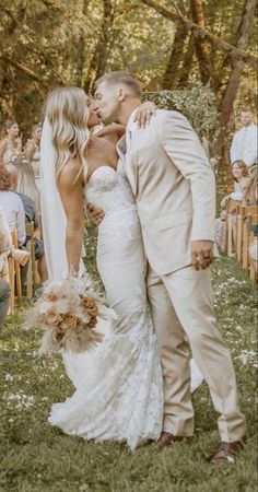 a bride and groom kissing in front of an outdoor ceremony