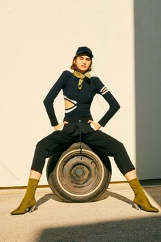 a woman sitting on top of a tire