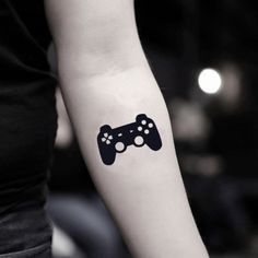 a woman with a tattoo on her arm holding a video game controller