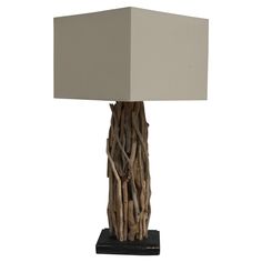 a lamp made out of driftwood on a black base with a white square shade