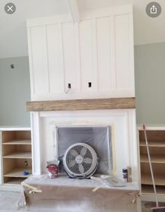 a room that has been painted white and is being worked on by someone with a fan