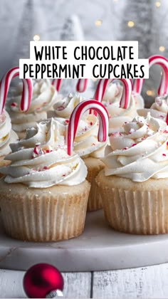 cupcakes with white frosting and red candy canes on a platter