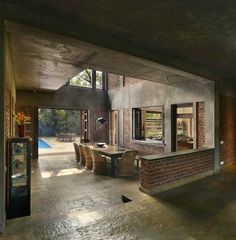 an open living room and dining area with brick walls, floor to ceiling windows, and sliding glass doors