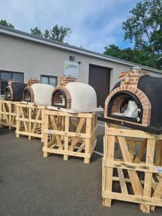 several wood fired pizza ovens sitting in front of a building