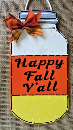 a sign that says happy fall y'all on it with an orange and yellow mason jar