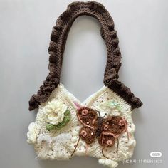 a crocheted purse with flowers and a butterfly on it