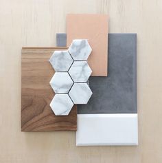 an assortment of tile and wood pieces on a wooden surface with white, grey, and brown accents