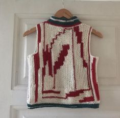 a knitted vest hanging on a door