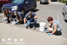 three people with buckets and gloves cleaning the pavement