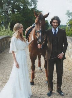 a man and woman standing next to a horse