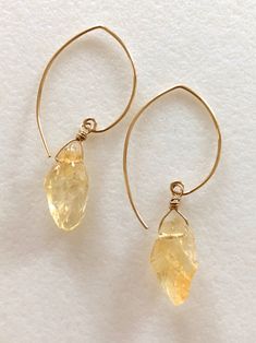 "Lovely honey amber yellow citrine nuggets wire wrapped in 14k gold fill on handmade matching gold fill ear wires. Rough nuggets are approximately 12 x 15mm and matched as closely as possible for natural gemstones. Total drop is 2\". Also in Sterling silver." Amber Wire Wrapped Drop Earrings, Amber Citrine Earrings With Ear Wire, Gold Teardrop Hand Wrapped Jewelry, Wire Wrapped Citrine Dangle Earrings, Delicate Gold Citrine Jewelry, Amber Citrine Drop Earrings, Gold Citrine Drop Earrings, Yellow Gold Wire Wrapped Jewelry For Healing, Amber Citrine Teardrop Earrings