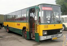 a yellow and green bus parked in a parking lot