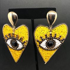 Yellow. Heart Shaped Pierced Earring With Decorative Eye Shape. Heart-shaped Summer Party Jewelry, Heart Shaped Summer Party Jewelry, Summer Party Heart-shaped Jewelry, Gold Heart Beaded Earrings For Party, Gold Heart Shaped Beaded Earrings For Party, Gold Heart-shaped Beaded Earrings For Party, Artistic Earrings, Yellow Heart, Eye Shape