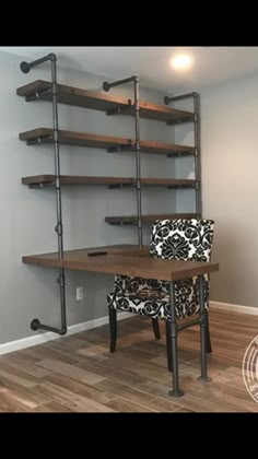 a room with a desk, chair and shelving unit