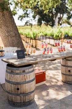 a table with wine glasses on top of it next to a barrel filled with drinks