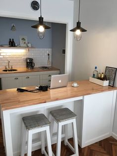 two stools sit at the bar in front of an open laptop on top of a counter