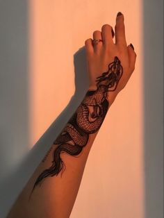 a woman's arm with a black dragon tattoo on the left side of her arm