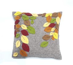 a gray pillow with leaves on it