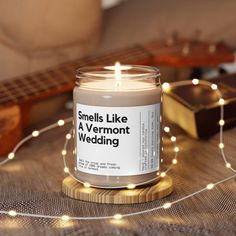 a candle sitting on top of a table next to a string of lights and a guitar