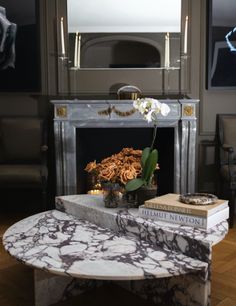 a living room with a marble coffee table and fireplace