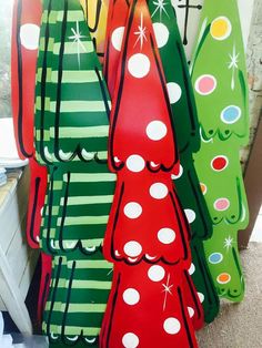 christmas trees are hanging on the wall in front of a storefront window, decorated with polka dots and stripes