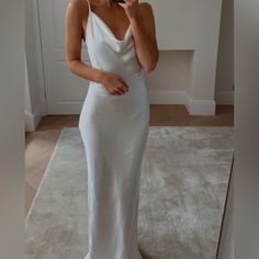 a woman in a white dress taking a selfie