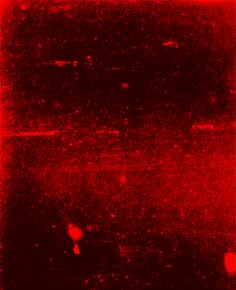 a red and black photo with some blurry lights on it's surface,