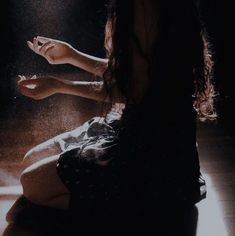 a woman sitting on the floor with her legs spread out and spraying water all over her body