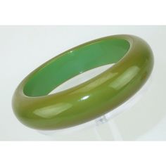 This is part of Chairish’s Costume Jewelry assortment.  A pair of 1950's plastic bangle bracelets in an ivory white and olive green.  The pair looked great when stacked together or wear them separately for different looks.  Please see the Modern & Moore Jewelry Collection home page for the additional plastic and Bakelite bangle bracelets shown in photographs 10 and 11.  Very good condition with light surface scratching though nothing objectionable.  The green bracelet measures 3.38" wide x .75" Vintage Lucite Bangle Bracelet, Retro Green Bangle Bracelets, Vintage Adjustable Green Bangle, Adjustable Green Vintage Bangle, Vintage Green Adjustable Bangle, Plastic Bangles, Bakelite Bangles, Green Bracelet, Ivory White