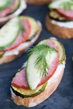 sandwiches with cucumber, tomato and dill on them are ready to be eaten