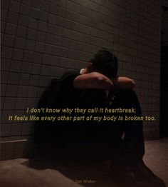 a man sitting on the ground in front of a wall with a quote about it