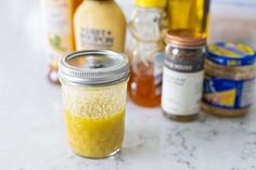 jars filled with yellow liquid sitting on top of a counter