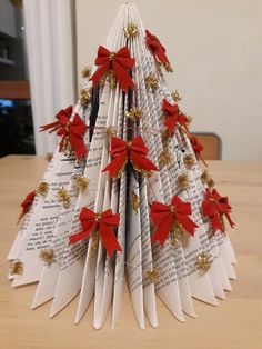 an origami christmas tree with red bows on it sitting on top of a table