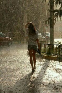 a woman walking in the rain with an umbrella