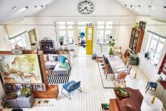 an overhead view of a living room and dining area with white walls, wood floors, and large windows