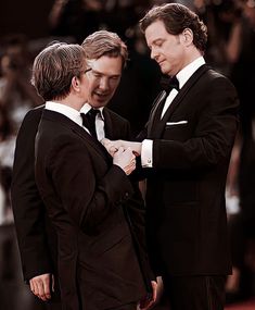 two men in tuxedos standing next to each other at a red carpet event