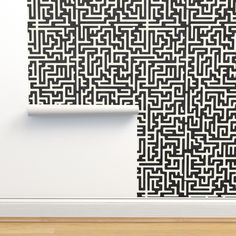 an abstract black and white wallpaper pattern on the wall next to a wooden floor