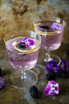 two glasses filled with purple liquid and blackberries